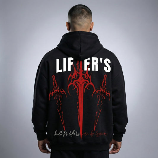 Person wearing a black hoodie with red and white designs and text on the back against a gray background