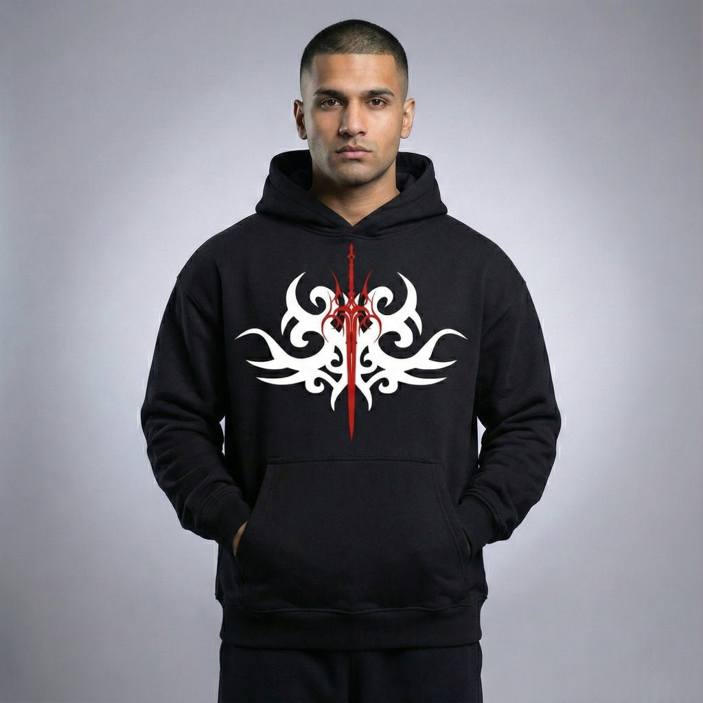 Man wearing a black hoodie with a white and red tribal design on a gray background