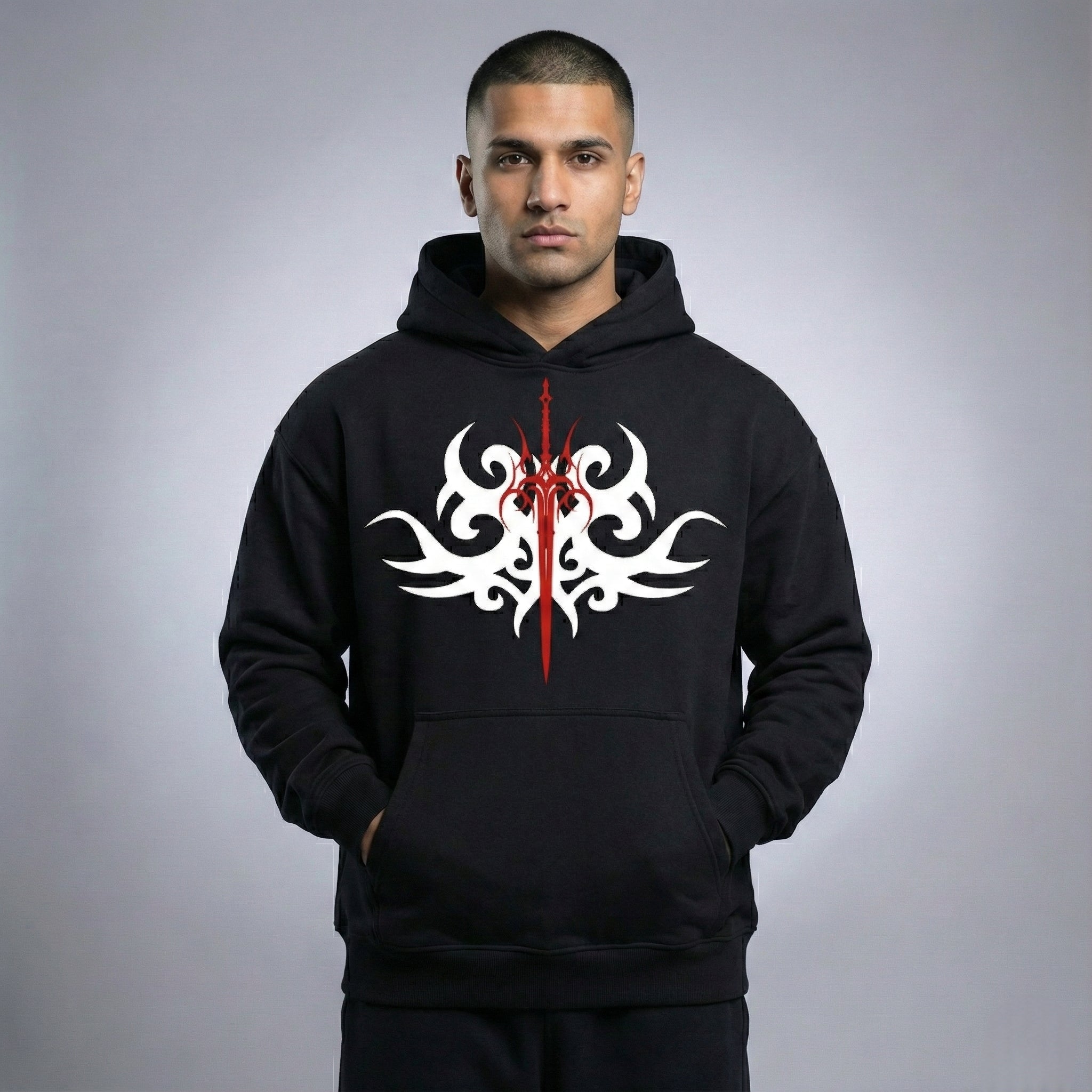Man wearing a black hoodie with a white and red tribal design on a gray background